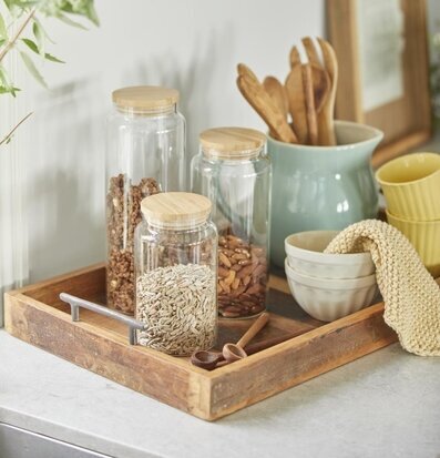 Bild av glasburkar på rustik träbricka i köket
