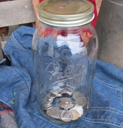 Bild av glasburk med mynt och gyllene metallock